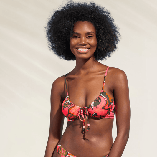 Mulher sorrindo usando Top Reversível com Armação Maaji em estampa colorida vibrante rosa e verde
