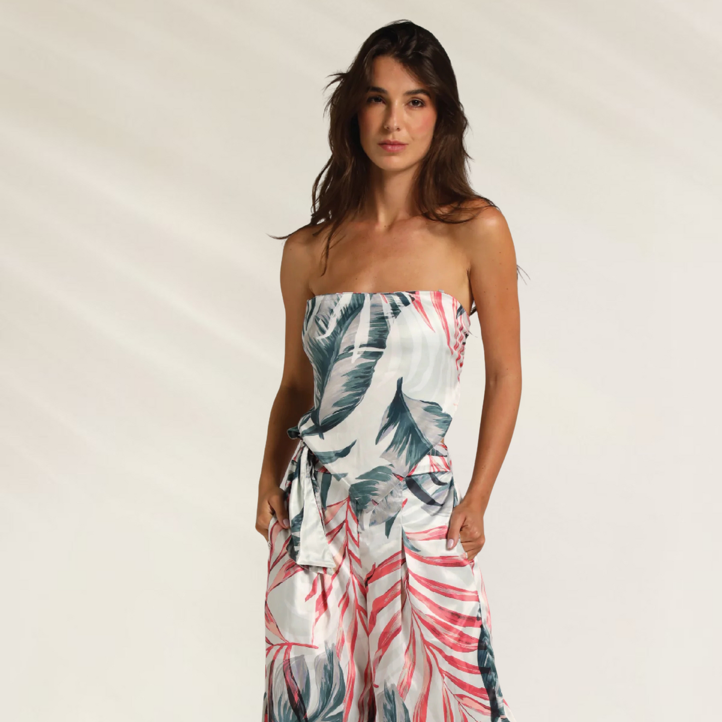 Mulher usando Calça Longa Refined Resort Cosita Linda com estampa de folhas em tons de azul e vermelho