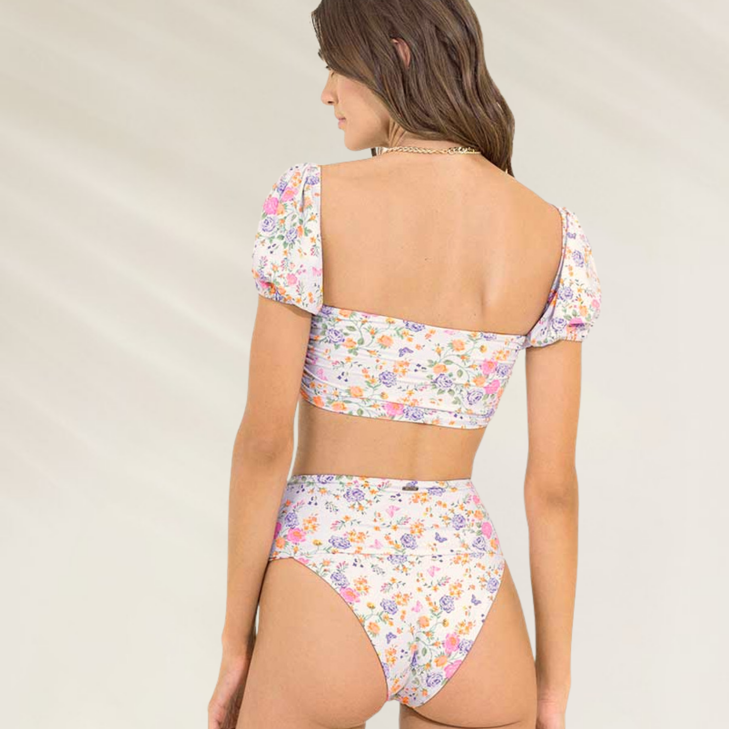 Mulher usando cueca cintura subida de padrão floral reversível da Maaji com estampa colorida e top combinando