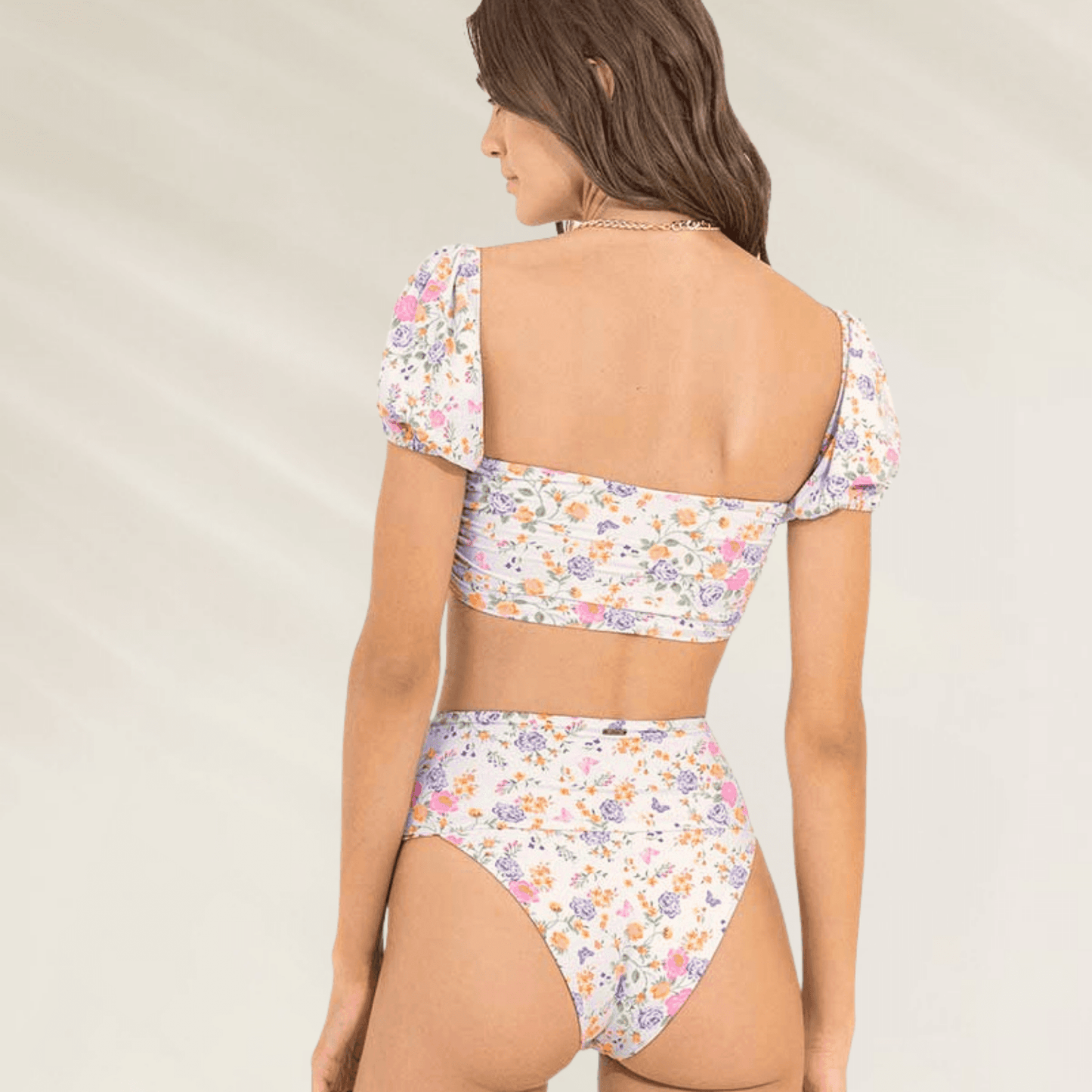 Mulher usando cueca cintura subida de padrão floral reversível da Maaji com estampa colorida e top combinando