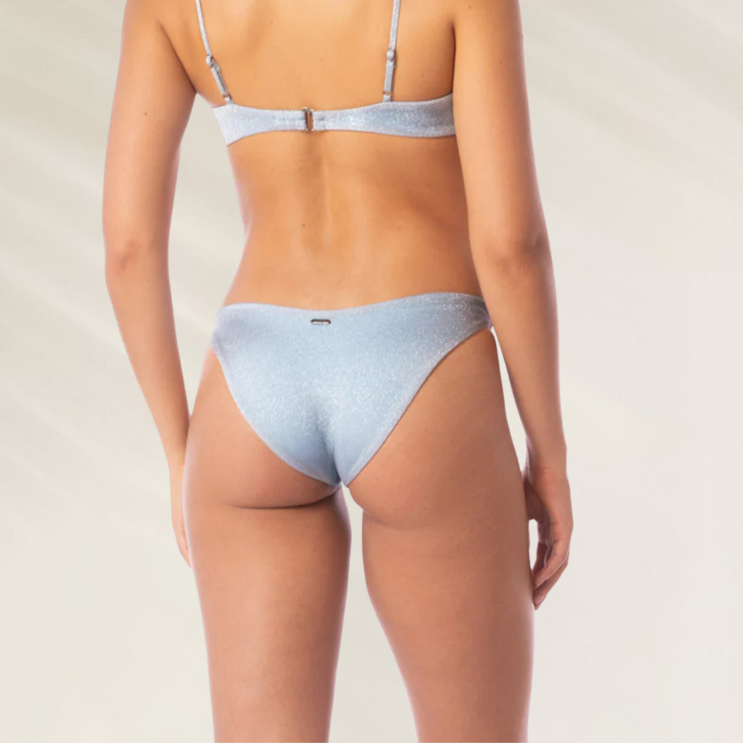 Mulher usando Cueca Reversível Splendour em Azul Prateado Maaji vista de costas com tecido brilhante