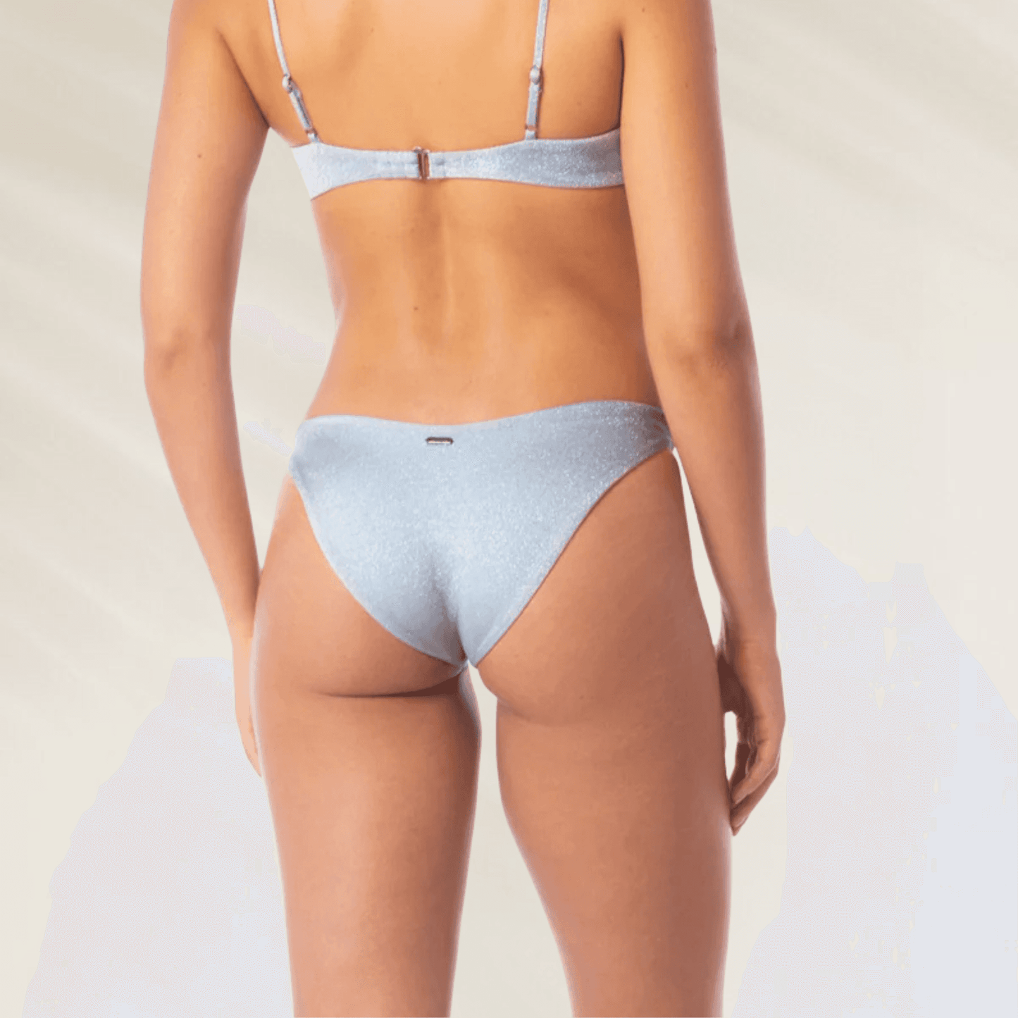 Mulher usando Cueca Reversível Splendour em Azul Prateado Maaji vista de costas com tecido brilhante