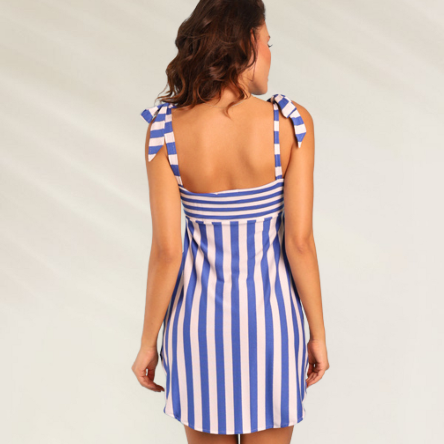 Mulher usando Vestido Curto às Riscas Azul e Branco Despi com alças de laço nas costas