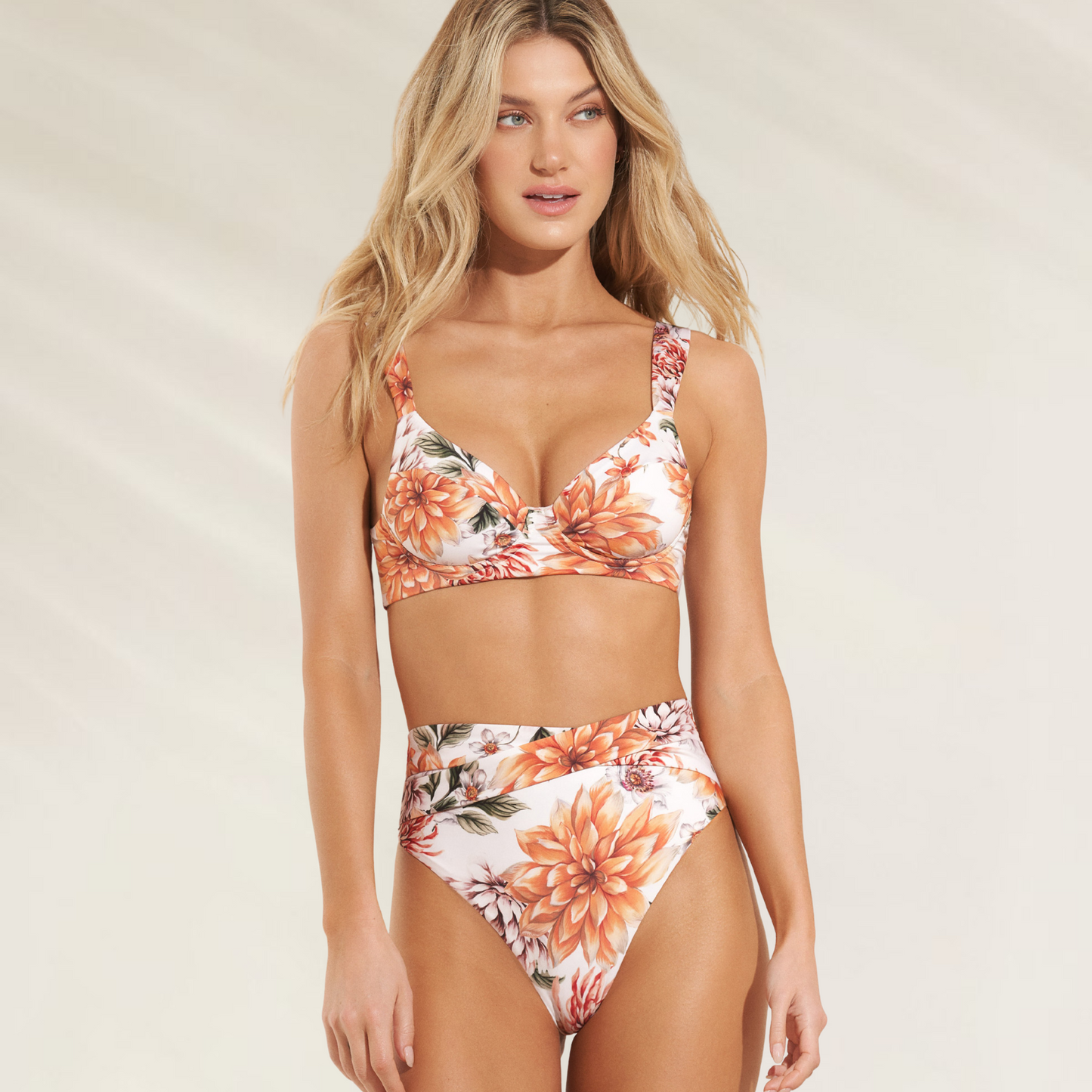 Mulher usando cueca reversível de cintura alta Maaji com estampa floral em tons laranja e branco