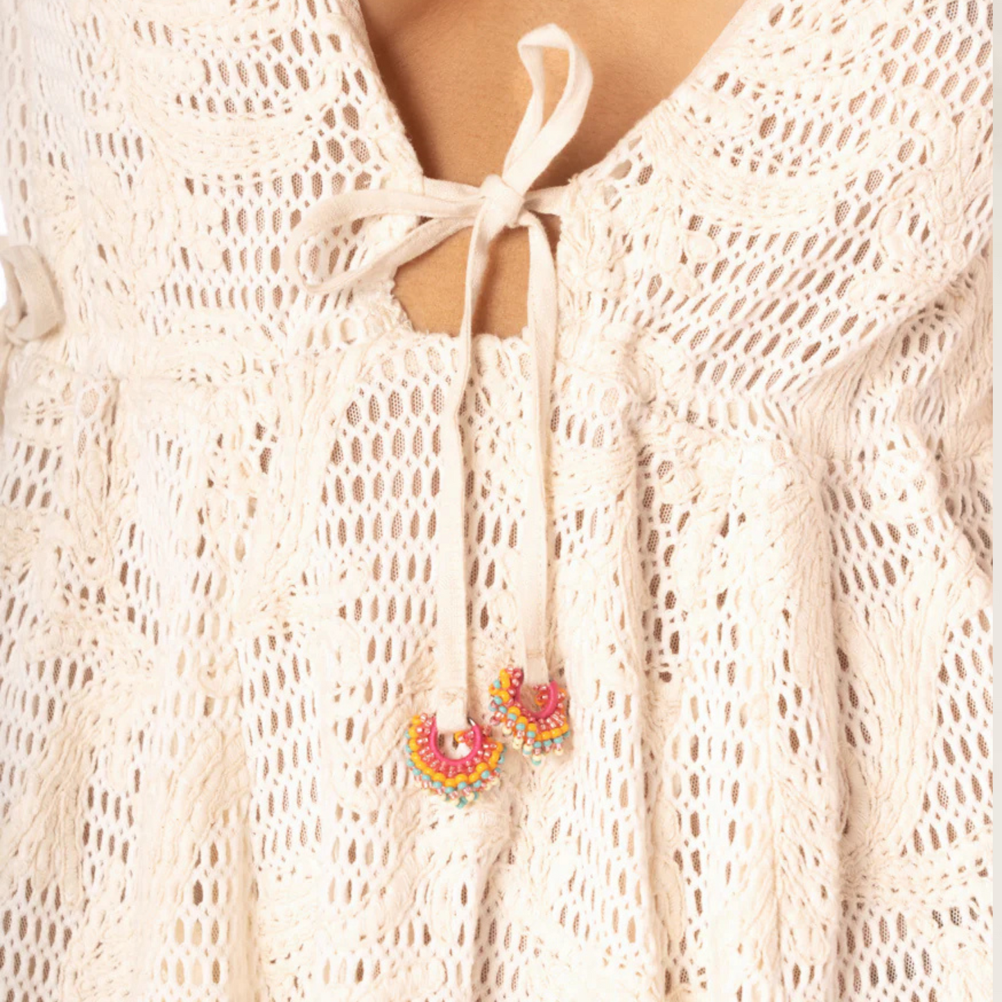 Delicadeza em cada detalhe – Vestido Curto Nova da Maaji em crochê branco com amarração frontal e detalhes coloridos
