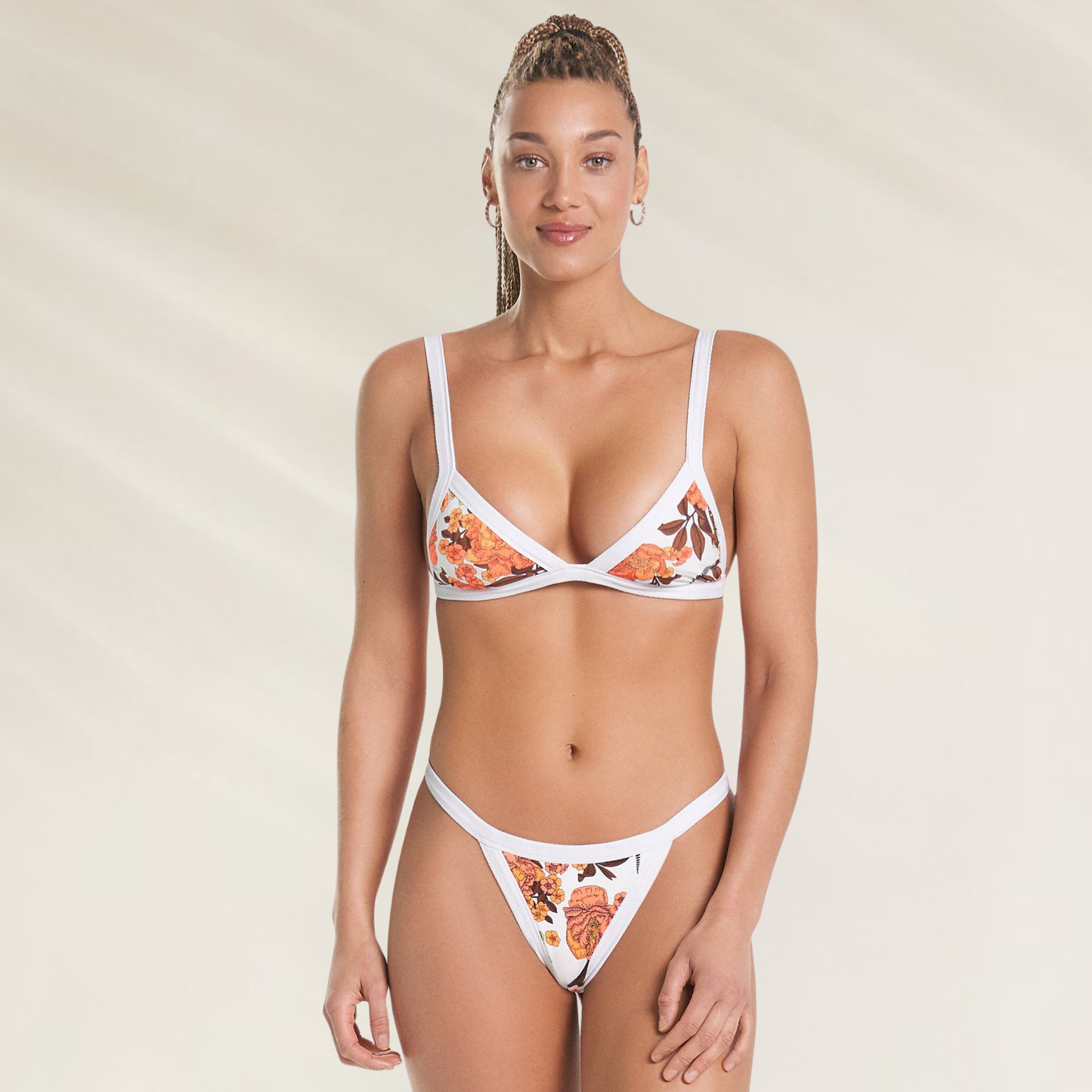 Top Reversível Maaji com Bordado Floral branco com detalhes em laranja usado por mulher em fundo claro