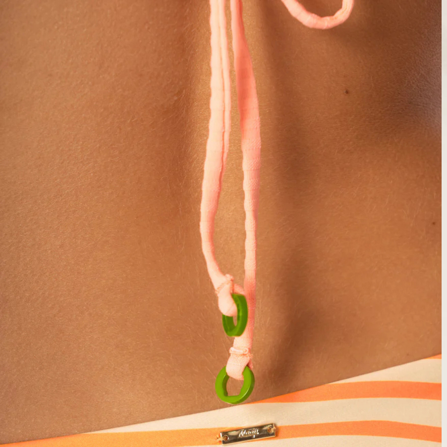 Detalhe do fecho do top reversível Victor da Maaji em tons laranja com alças rosas e argolas verdes