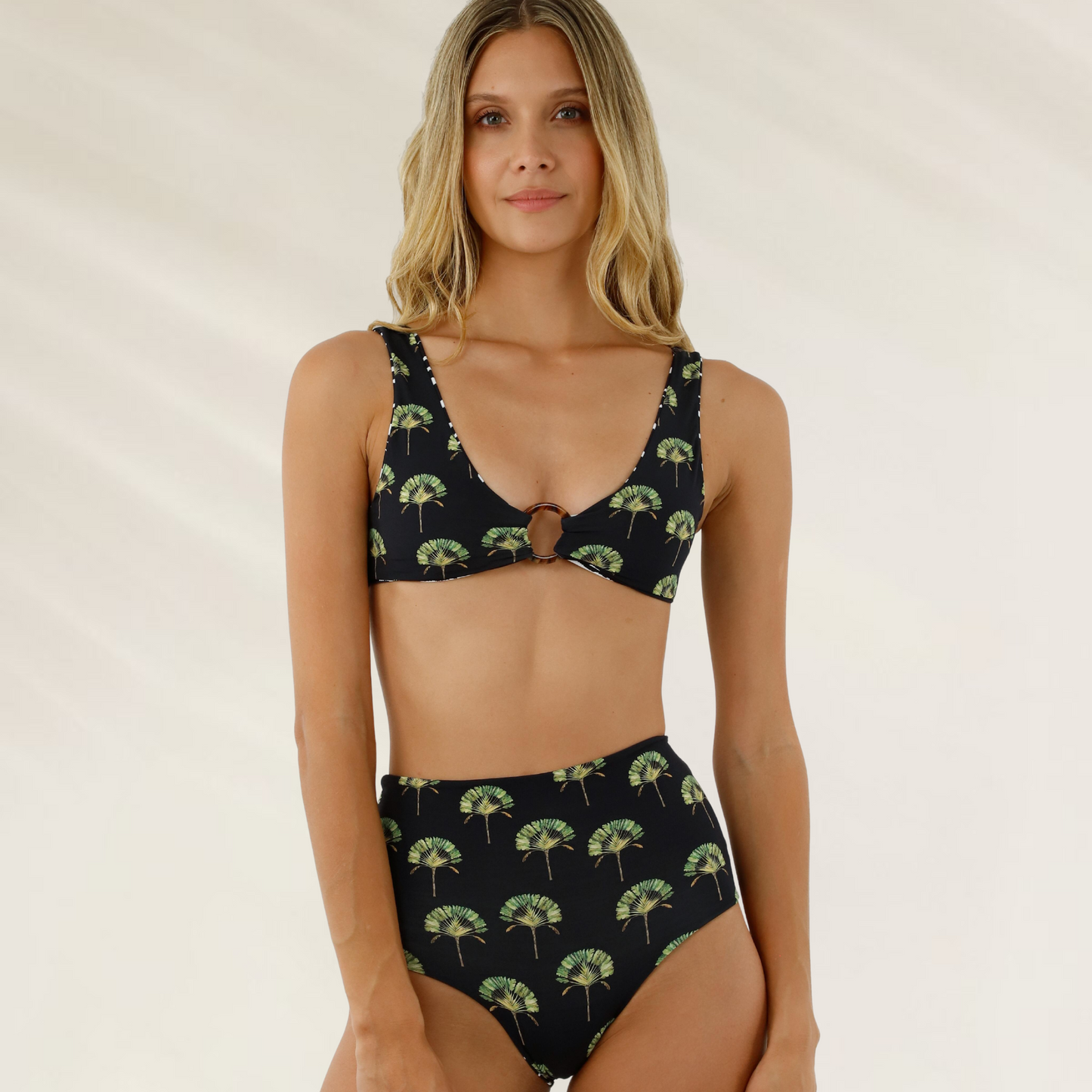Modelo usando Cueca Reversível Cintura Alta Malai preta com estampa de folhas verdes