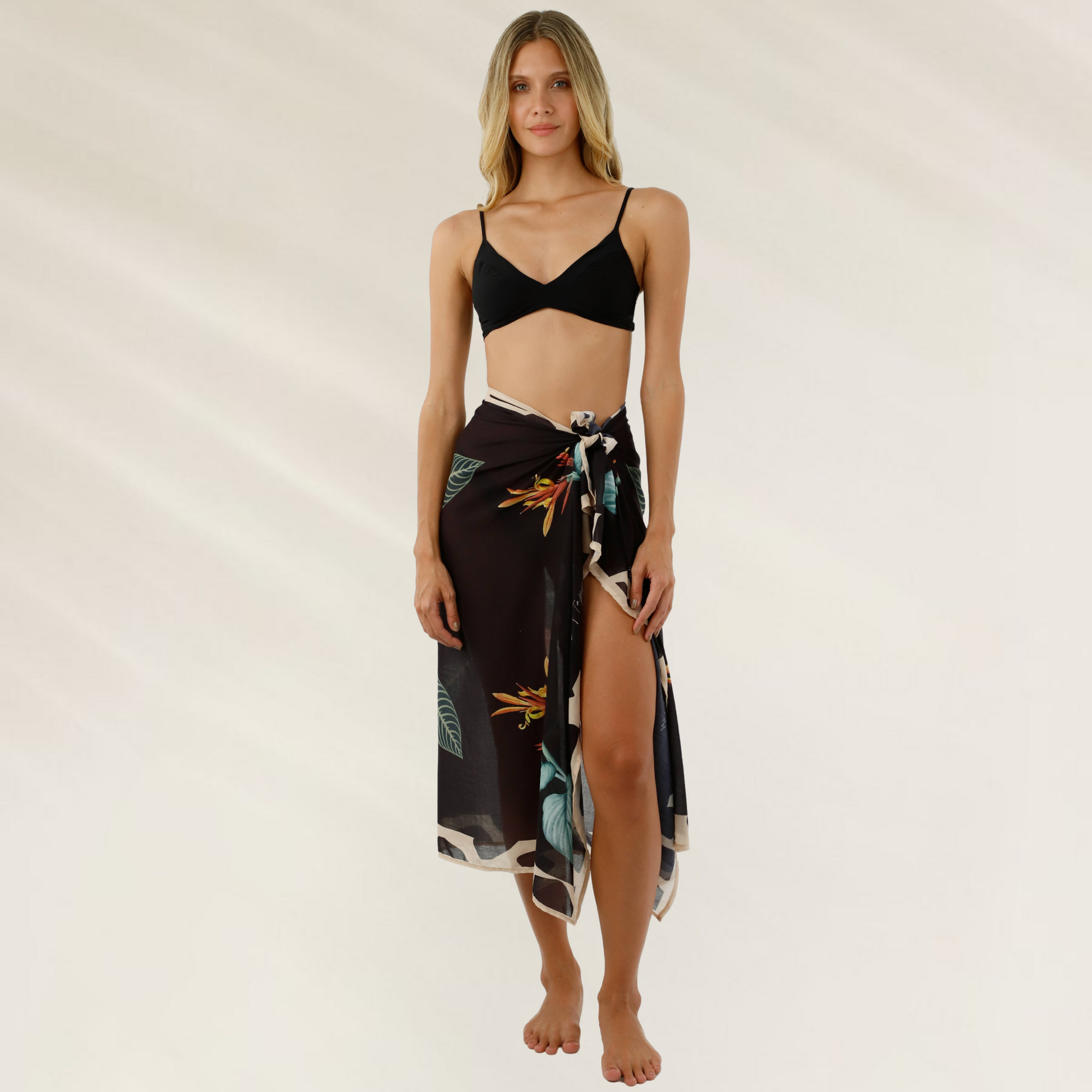 Mulher vestindo Pareo Malai Floral em Viscose – Versatilidade com Toque Tropical com estampa floral escura e nó na cintura