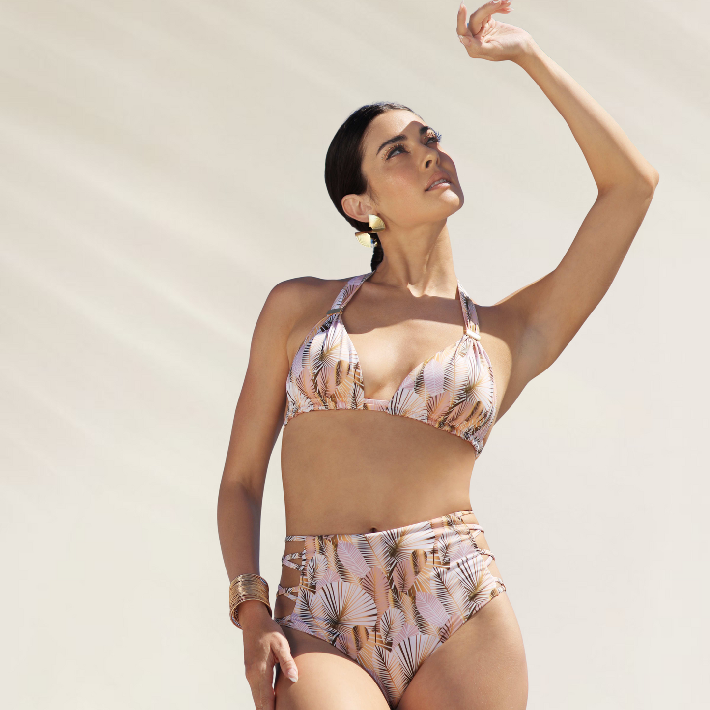Top Triângulo com Detalhe Dourado Mystical estampado com folhas, usado por mulher em pose elegante