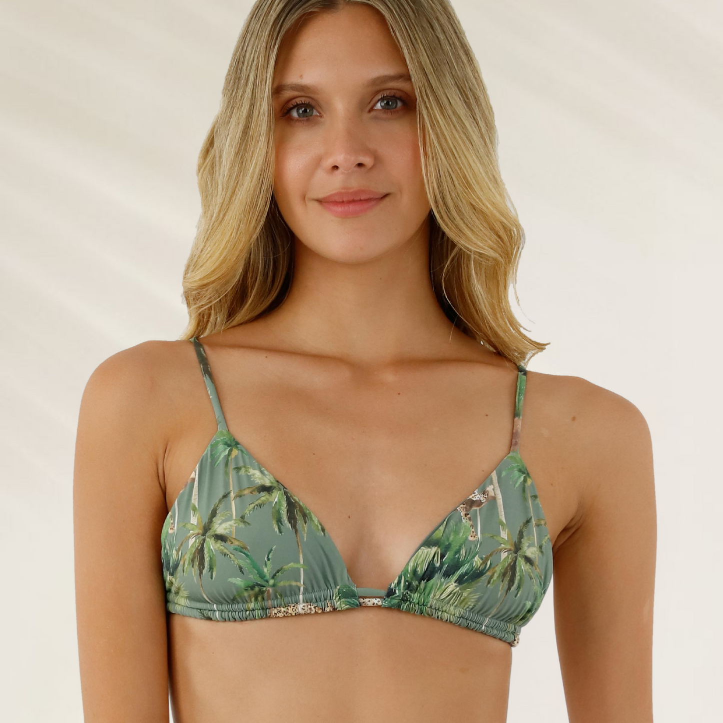 Top Triângulo Reversível Malai em verde com estampa tropical usado por mulher loira