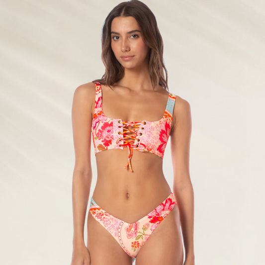 Mulher usando cueca reversível Valerya Maaji com estampa floral em tons de rosa e laranja
