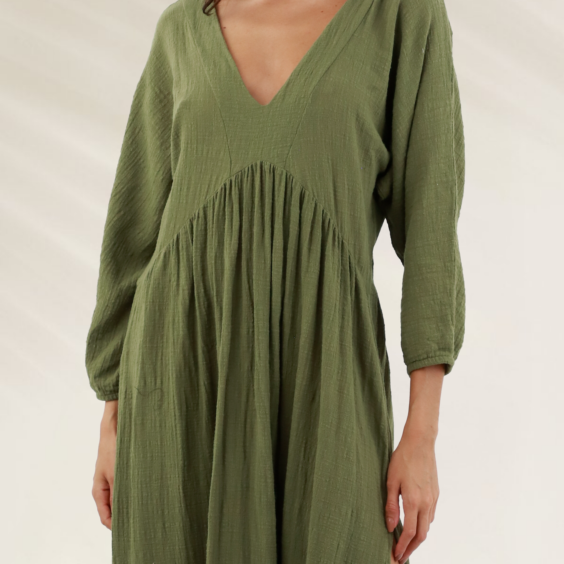 Vestido longo Malai em viscose com decote profundo na cor verde oliva, com mangas longas e corte fluido.
