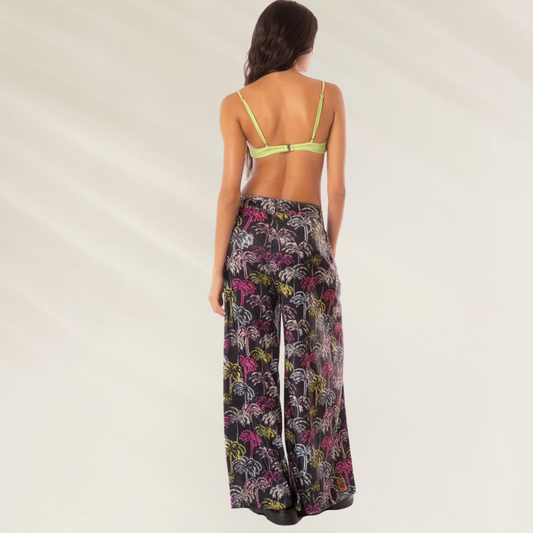 Calças Largas Stella Maaji com estampa colorida em fundo preto, modelo feminino visto de costas