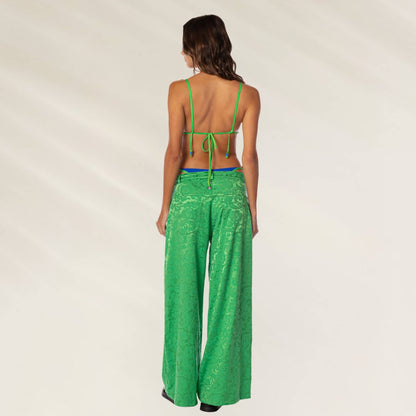 Modelo de calça verde em tecido texturizado, estilo largo da marca Maaji, vista de costas