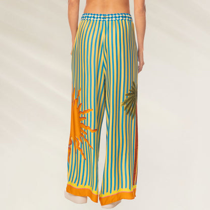 Calças Tropic Camouflage Ophelia da Maaji com estampa de sol e palmeiras em amarelo e azul
