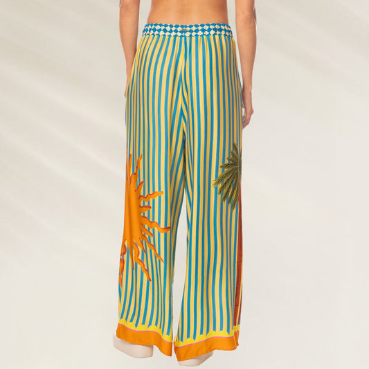 Calças Tropic Camouflage Ophelia da Maaji com estampa de sol e palmeiras em amarelo e azul