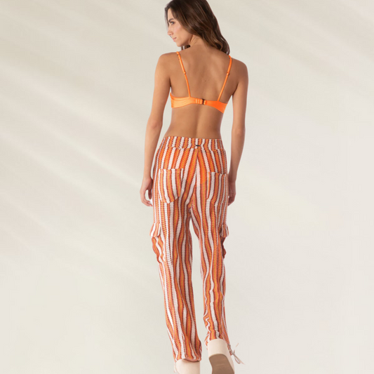 Modelo vestindo Calças Cargo Elodie em Crochet da Maaji listradas em tons de laranja e branco