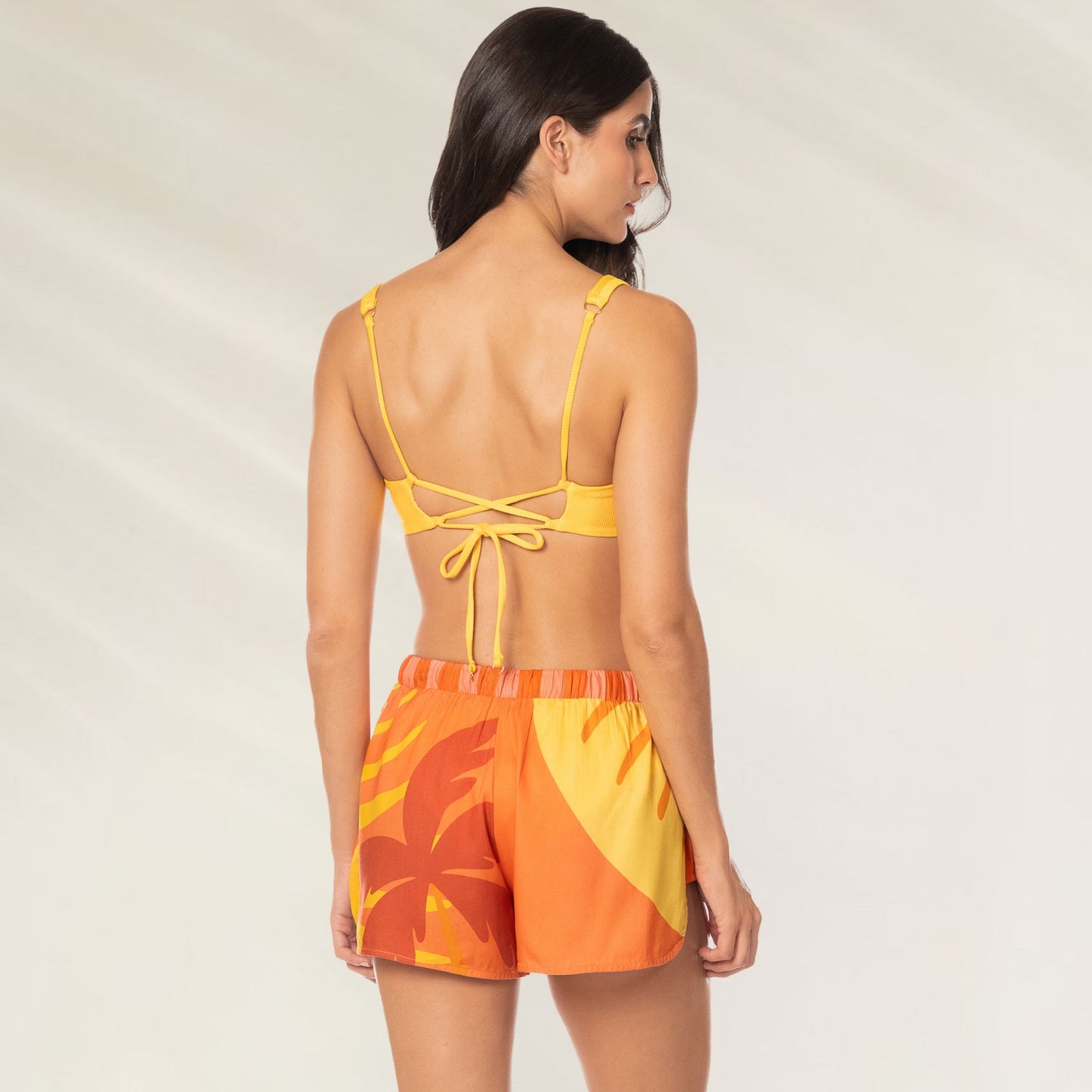 Modelo usando calção amarelo e laranja Calções Instinct Print Ryto com design tropical