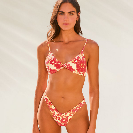 Mulher usando cueca de biquini Maaji com estampa floral em tons vermelhos e amarelos Cueca com Corte Latino Maaji – Conforto com Toque Sensual
