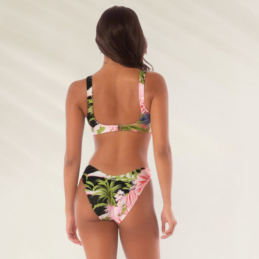 Modelo usando cueca de biquíni reversível Maaji com estampa tropical vibrante na parte traseira
