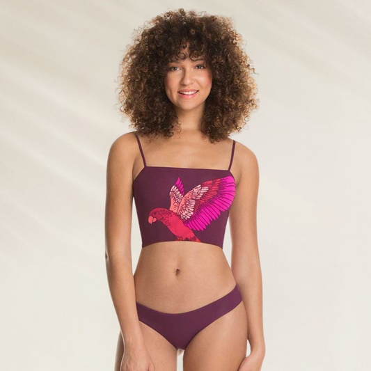 Cueca reversível Maaji de corte médio e cor tinto em modelo feminino com top estampado de pássaro