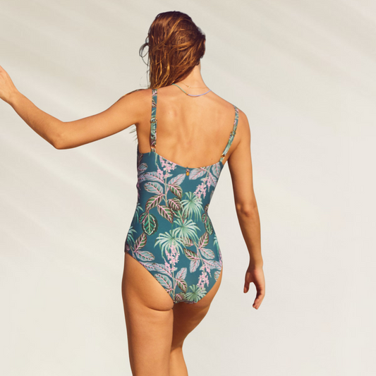 Mulher de costas usando Fato de Banho Reversível com Aberturas Frontais Malai estampado verde com folhagens