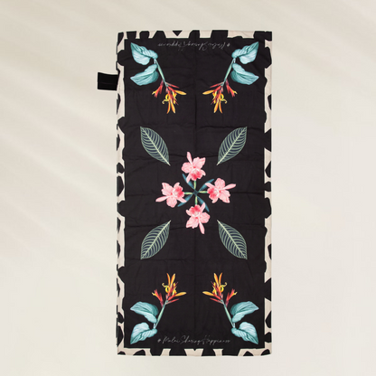 Toalha de Praia Malai – Leveza, Estilo e Praticidade com estampa floral colorida e fundo preto