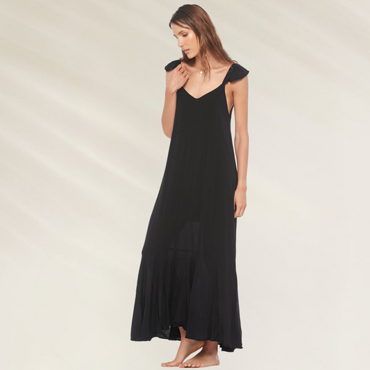 Vestido Preto Longo com Decote em V Malai em tecido leve usado por mulher em fundo claro