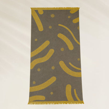 Toalha Golden Waves da Kalua com design moderno em fundo cinza e detalhes amarelos