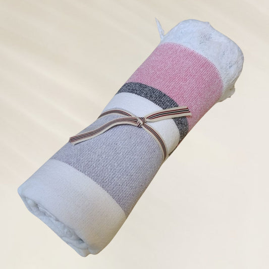 Toalha Pastel Multicolor da Kalua, enrolada com listras suaves e textura macia