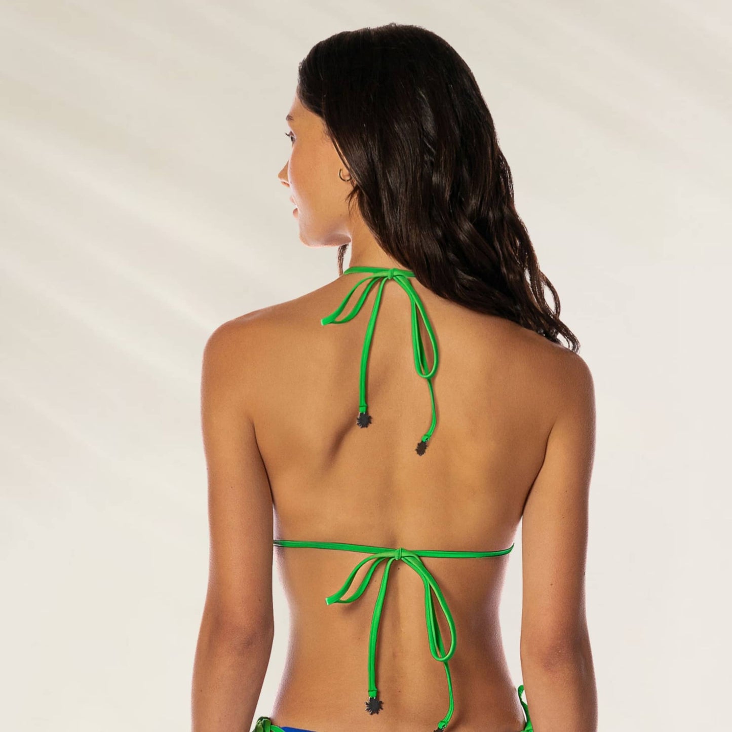 Mulher usando o Top de Biquíni Balmy Azul e Verde com detalhes em corda verde na parte de trás